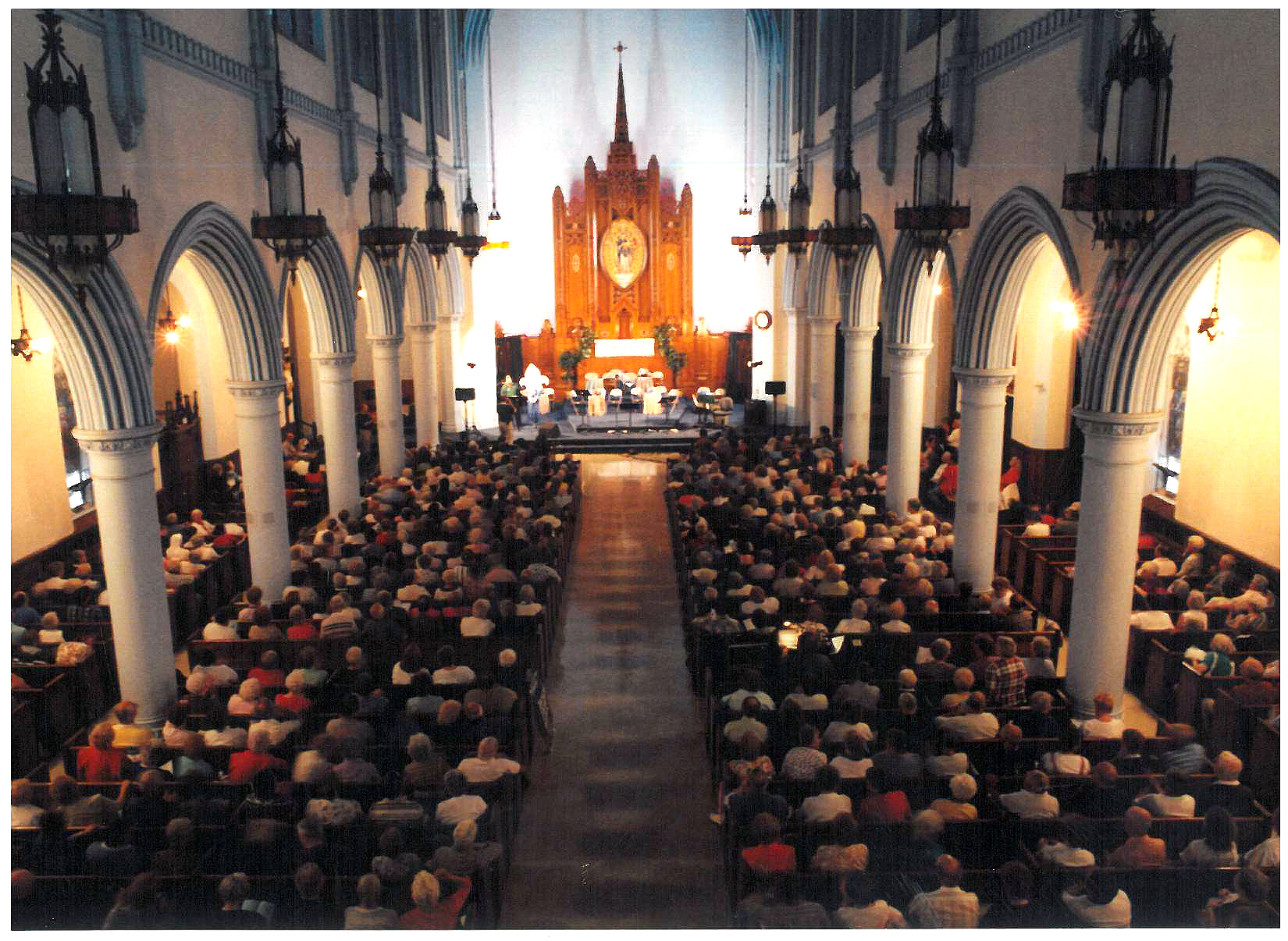 interior of church with people seated in pews and alter lit brightly